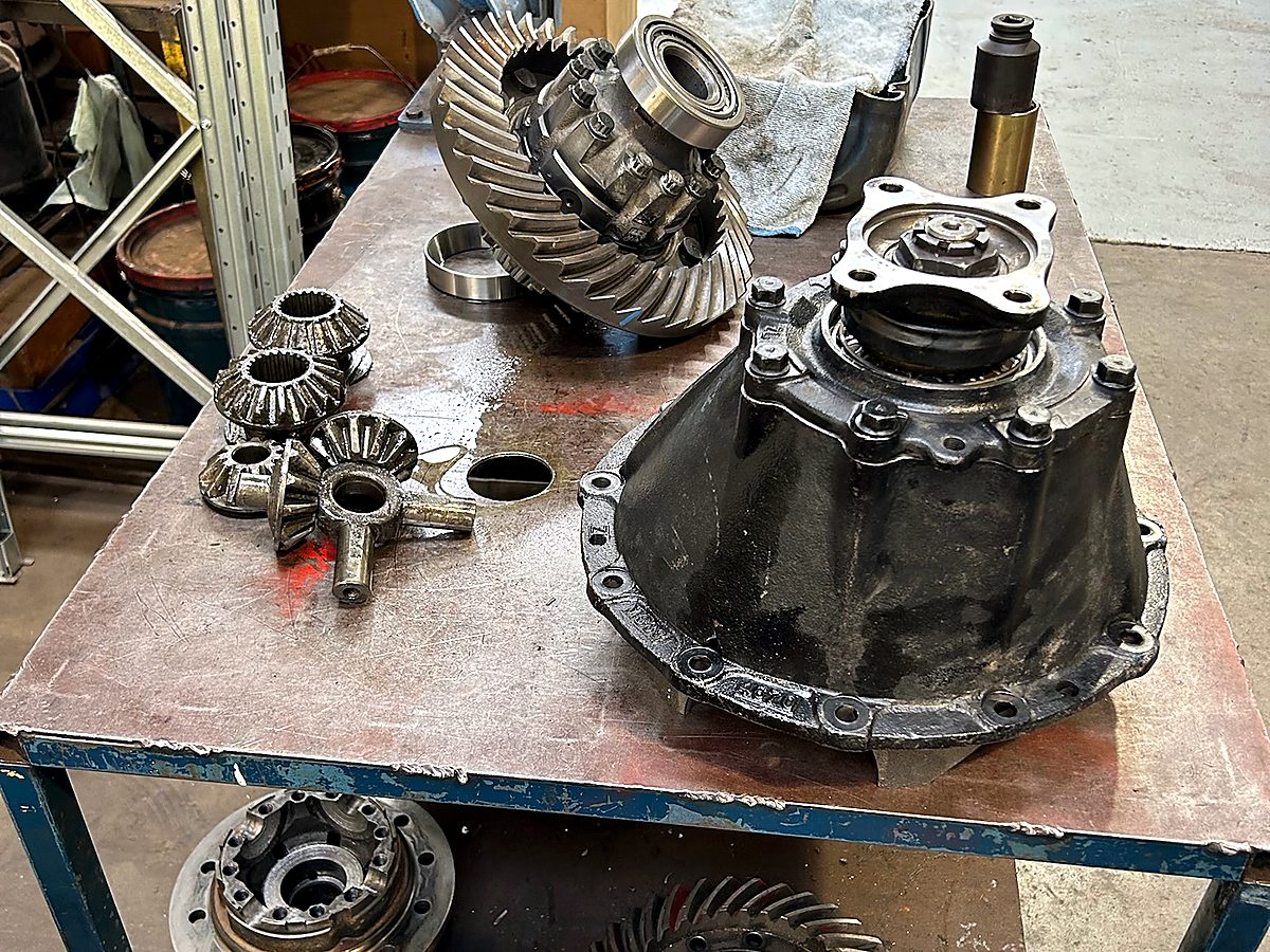 Stripped truck differential, crown wheel and pinion, and diff carrier on the workshop bench at Naturaliste Diesel Services
