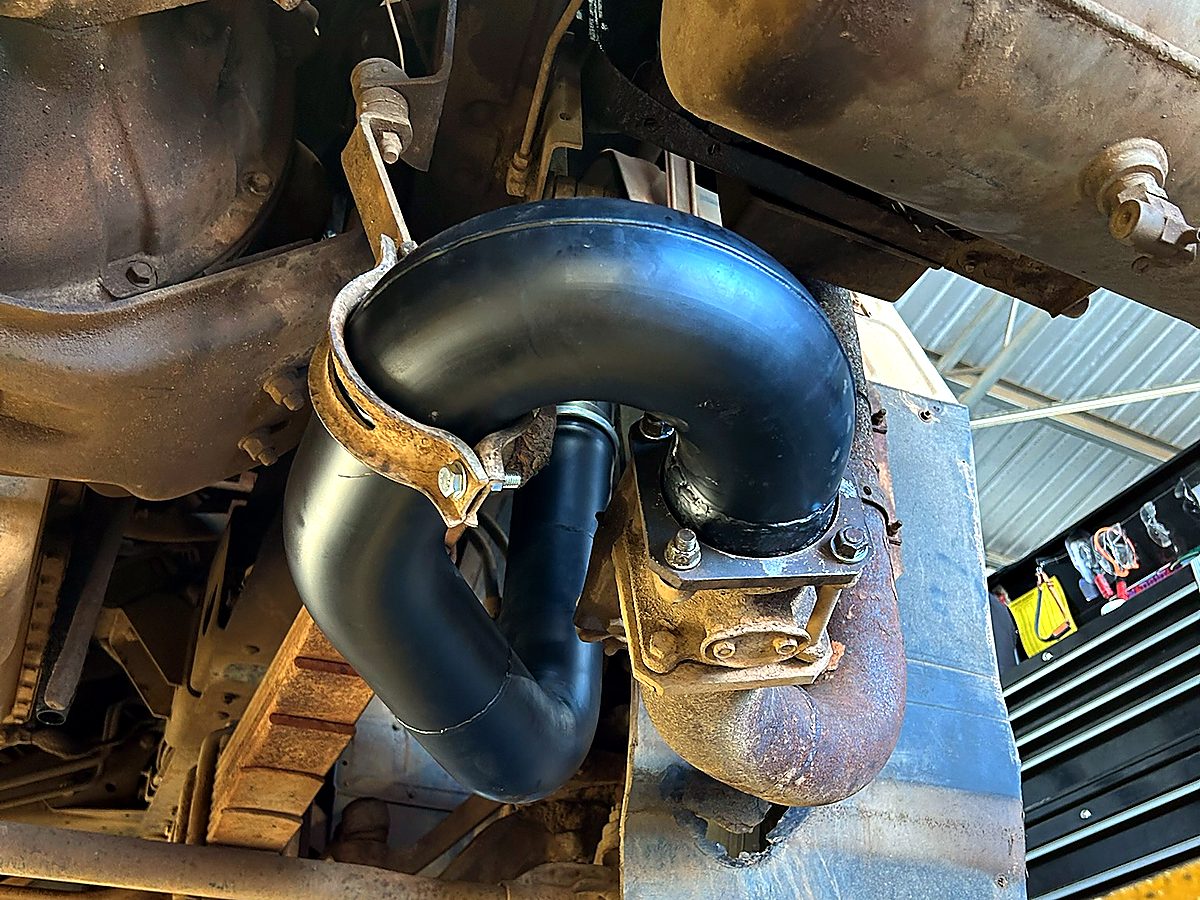 Newly fabricated heavy-vehicle exhaust pipe fitted underneath a truck on the hoist at Naturaliste Diesel Services
