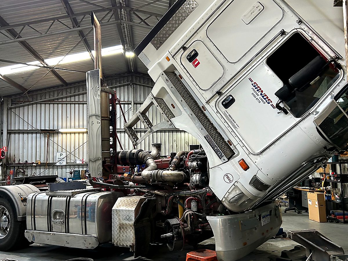 Kenworth prime mover with cab tilted forward for scheduled servicing in the Naturaliste Diesel Services workshop